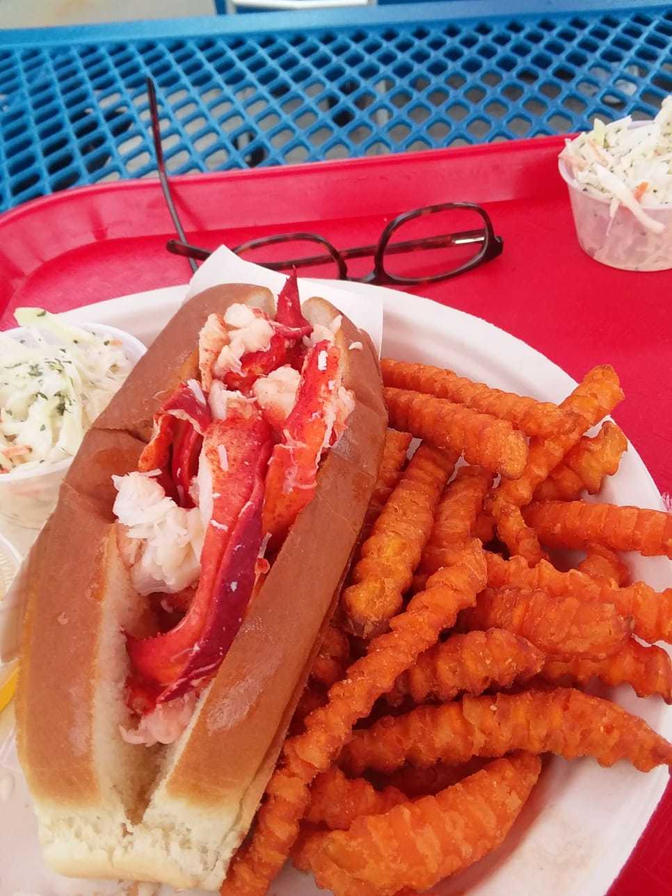 A lobster roll, sweet potato fries, and coleslaw